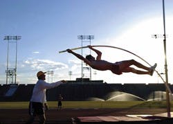 Lobo pole vaulter Derek Mackel gets a spot from assistant track and field coach Scott Steffan during practice Sunday at the Great Friends of UNM Track and Field Stadium. 
