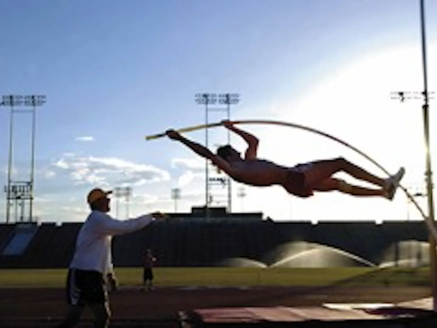 Lobo pole vaulter Derek Mackel gets a spot from assistant track and field coach Scott Steffan during practice Sunday at the Great Friends of UNM Track and Field Stadium.