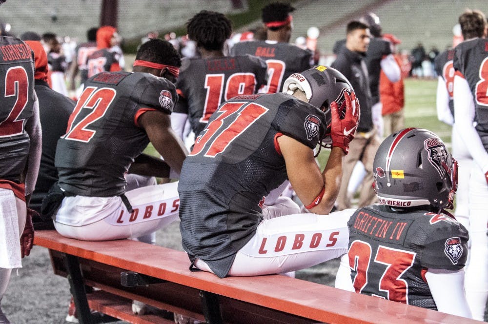 Wide receiver Thomas Vieira (center) holds his head in his hands as the clock winds to zero during UNM’s loss to San Diego State. The Lobos gave up 17 straight points in the fourth quarter, throwing away their nine point lead.&nbsp;