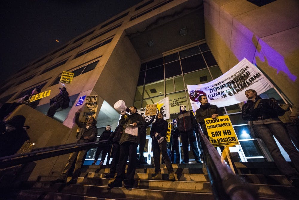 Protesters stand on the steps of the&nbsp;downtown Albuquerque Police Department station during an anti-Trump protest Friday night.