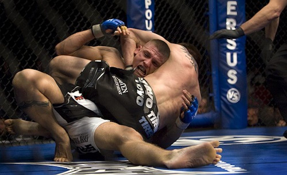 Carlo Prater, white trunks, taps out as Carlos Condit holds him in a headlock during the World Extreme Cagefighting event at the Santa Ana Star Center on Wednesday. Condit beat Prater in Round One, successfully defending his WEC welterweight title.