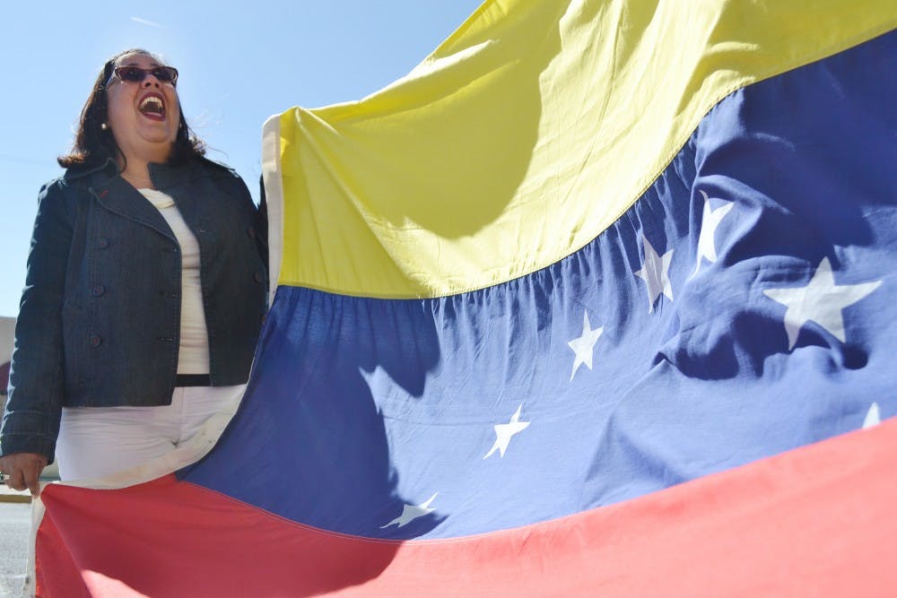 	Rosa Maria Edmunds, a Venezuelan who has been living in Albuquerque for 13 years, chants her country’s name in a protest in front of the UNM Bookstore on Saturday. Edmunds was one of about 80 Albuquerque protesters in support of the anti-government student protests in Venezuela that have been going on since Feb. 12. “I’d like to raise my flag to have parties,” she said. “I think it’s sad that this is happening. We’re doing wrong things.”
