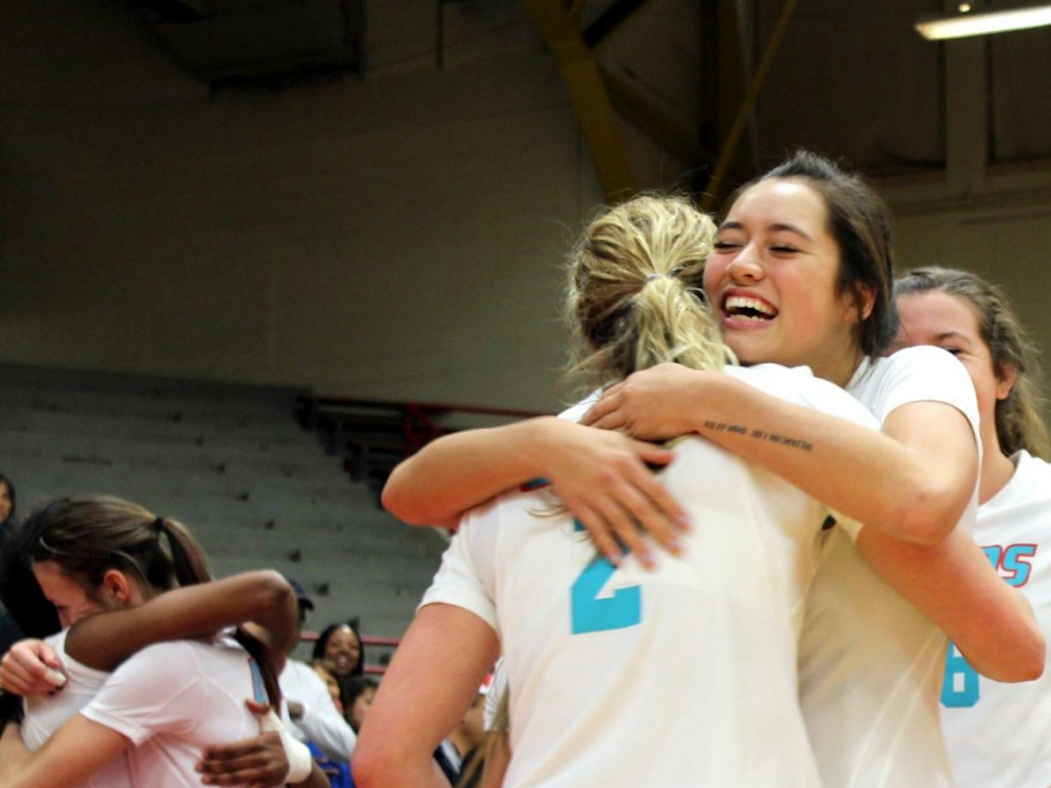 Senior Hannah Johnson is embraced by sophomore Eastyn Baleto after playing her last home game at Senior Night in Johnson Gym Wednesday night. The Lobos swept the series against the Utah State Aggies.