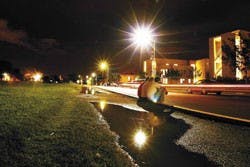 UNM exchange students from closestj1, Peter Blackett, Matt Harrington and Dave Ferris sit on the path around Johnson Field while they wait for friends Friday night.  