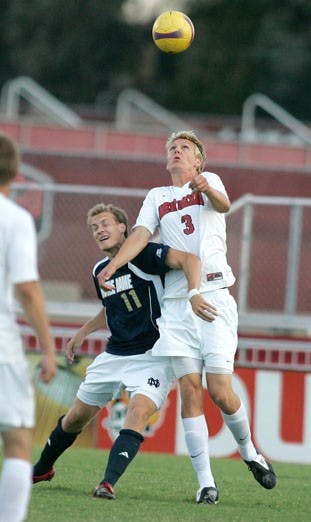 UNM goalkeeper Eric Staver blocks a shot by Notre Dame's Bright Dike in the Lobos' lone exhibition game Wednesday. The Lobos eventually went on to lose in double overtime, 2-1.  