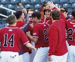 Former UNM slugger Chris Carlson, rear center, is congratulated by teammates after hitting a home run against the University of Northern Colorado on March 5.