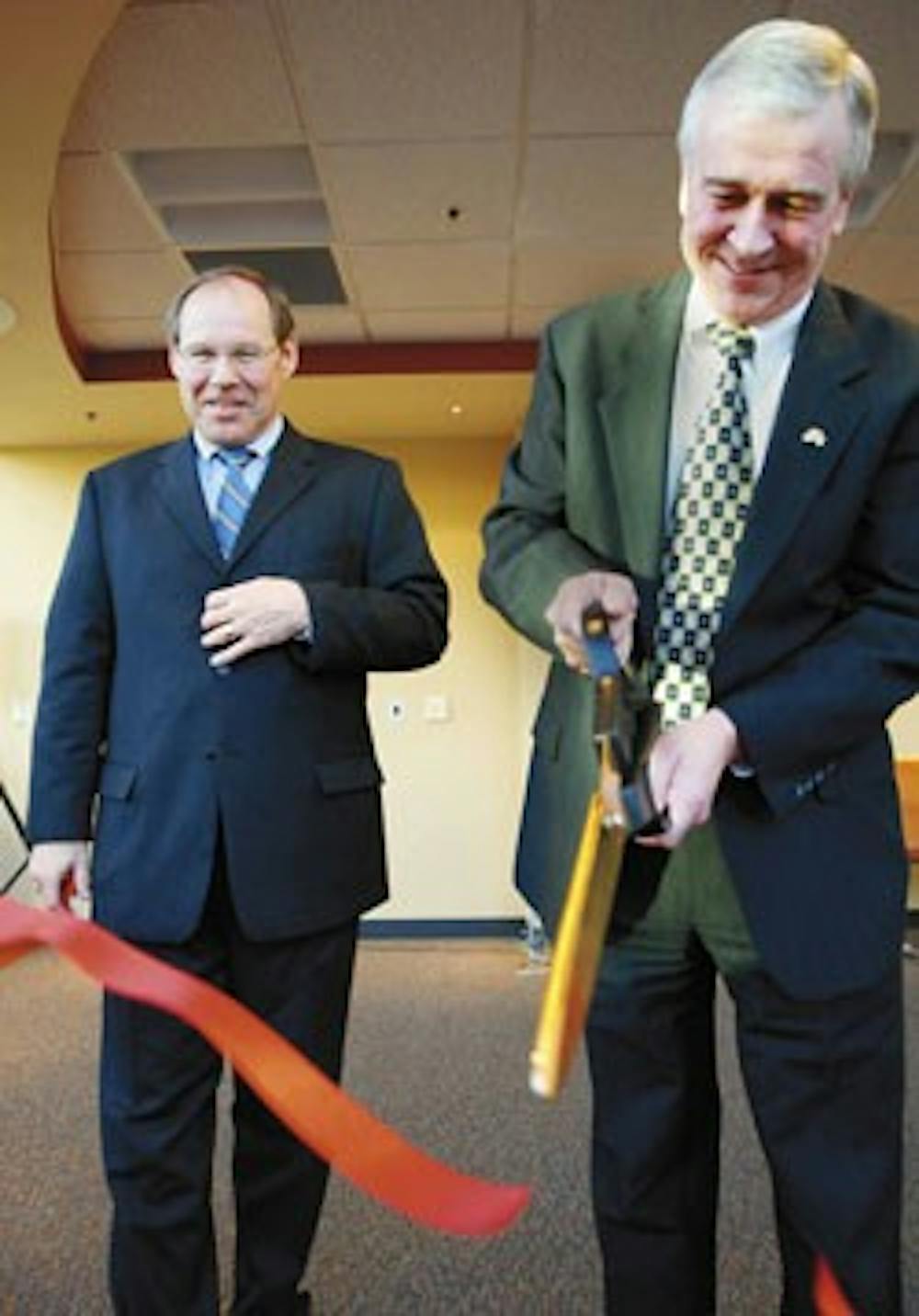 UNM President David Harris watches Wells Fargo regional president Greg Winegardner cut a ribbon Friday for the opening of the new Anderson Student Event Center and Financial Services Center.