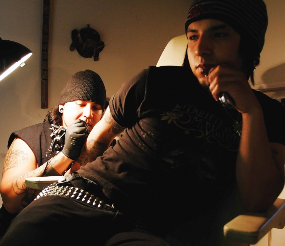 Tattoo artist Dominic Sanchez inks the Virgin Mary on Toney Herrera's forearm on Monday at Full Spectrum II tattoo parlor at 4770 Montgomery Blvd. N.E., Suite 120.