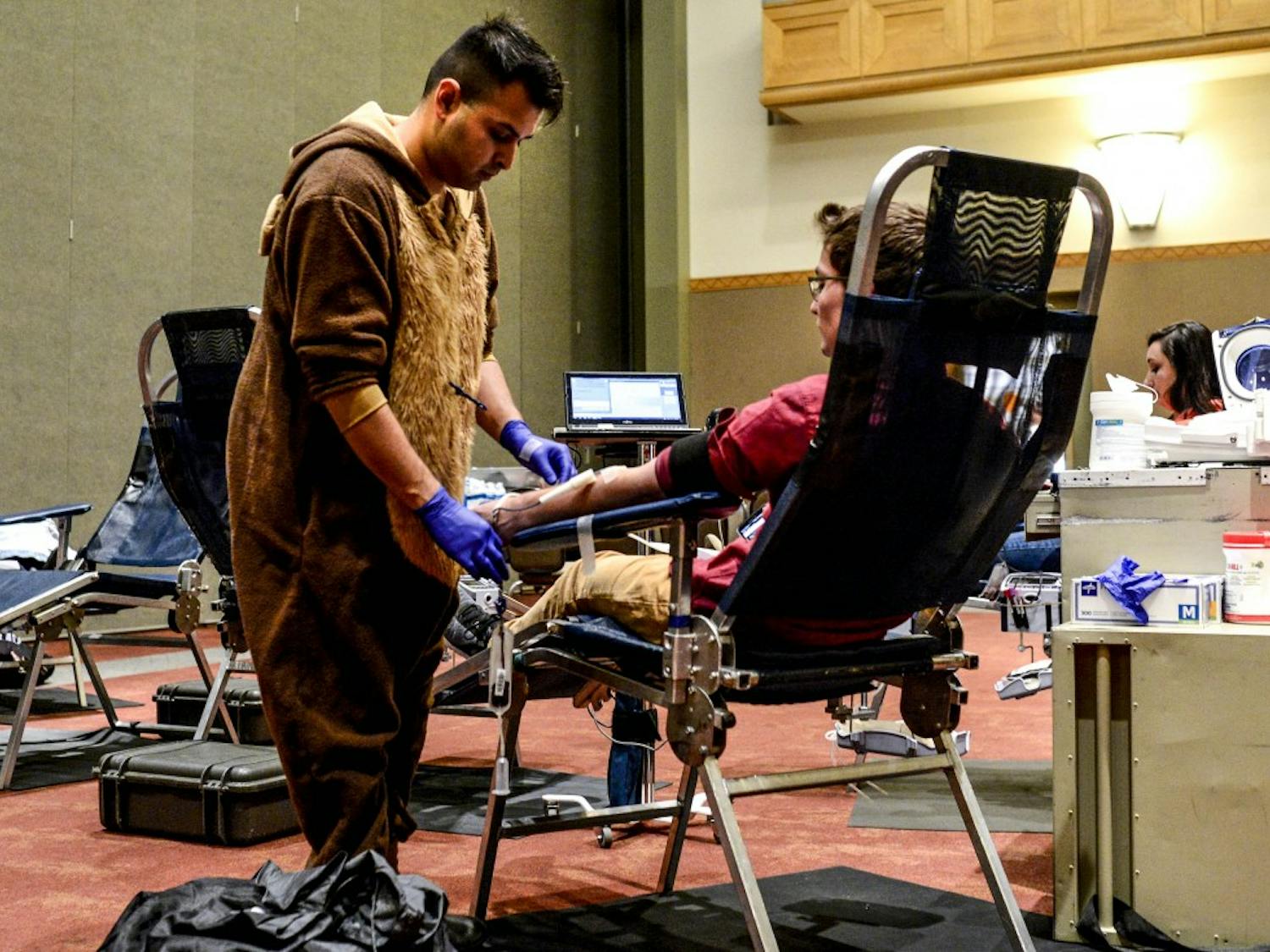 Jeremiah Ramirez adjusts the phlebotomy tube on a student at an ASUNM Community Experience Halloween Blood Drive in one of the SUB Ballrooms on Oct. 31, 2017.