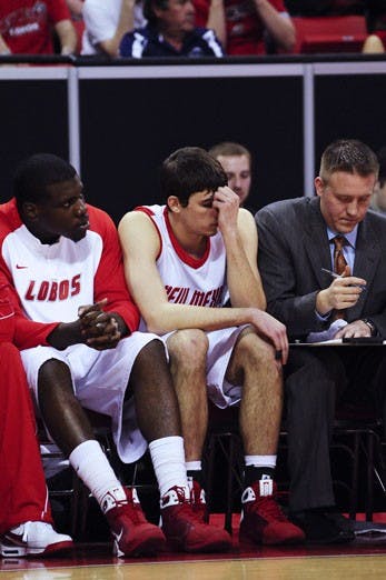 Daniel Faris, center, sits on the bench after fouling out in Thursday's game against Wyoming in Las Vegas, Nev. The Lobos lost 75-67, eliminating them from the Mountain West Conference Tournament.
