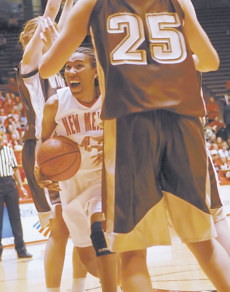 Guard Brandi Kimble charges past Wyoming forward Justyna Podziemska during Sunday's game at The Pit. The Lobos won 50-43.