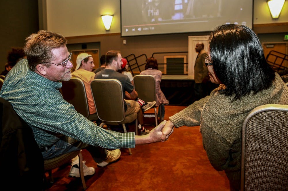 Loreal Black Shawl, right, shakes hands with Larry Ostrem at the Coach Ken Carter talk at the UNM SUB ballroom on Tuesday, Oct. 10, 2017.
