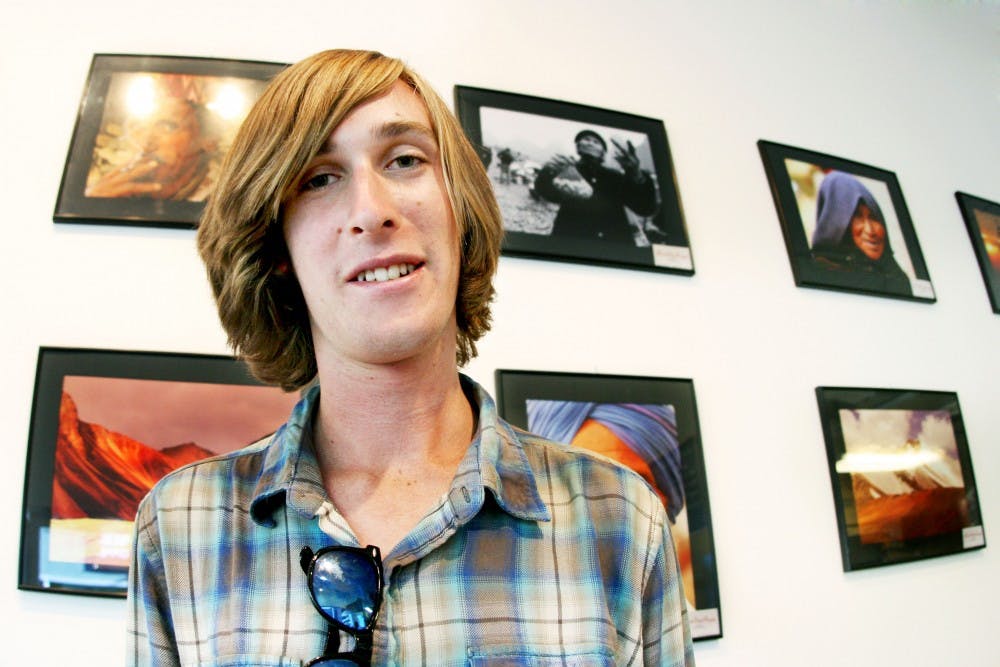 	Jeffrey Hertz stands in front of his exhibition of his travel-based photography. In addition to his photography, Hertz also writes poetry.