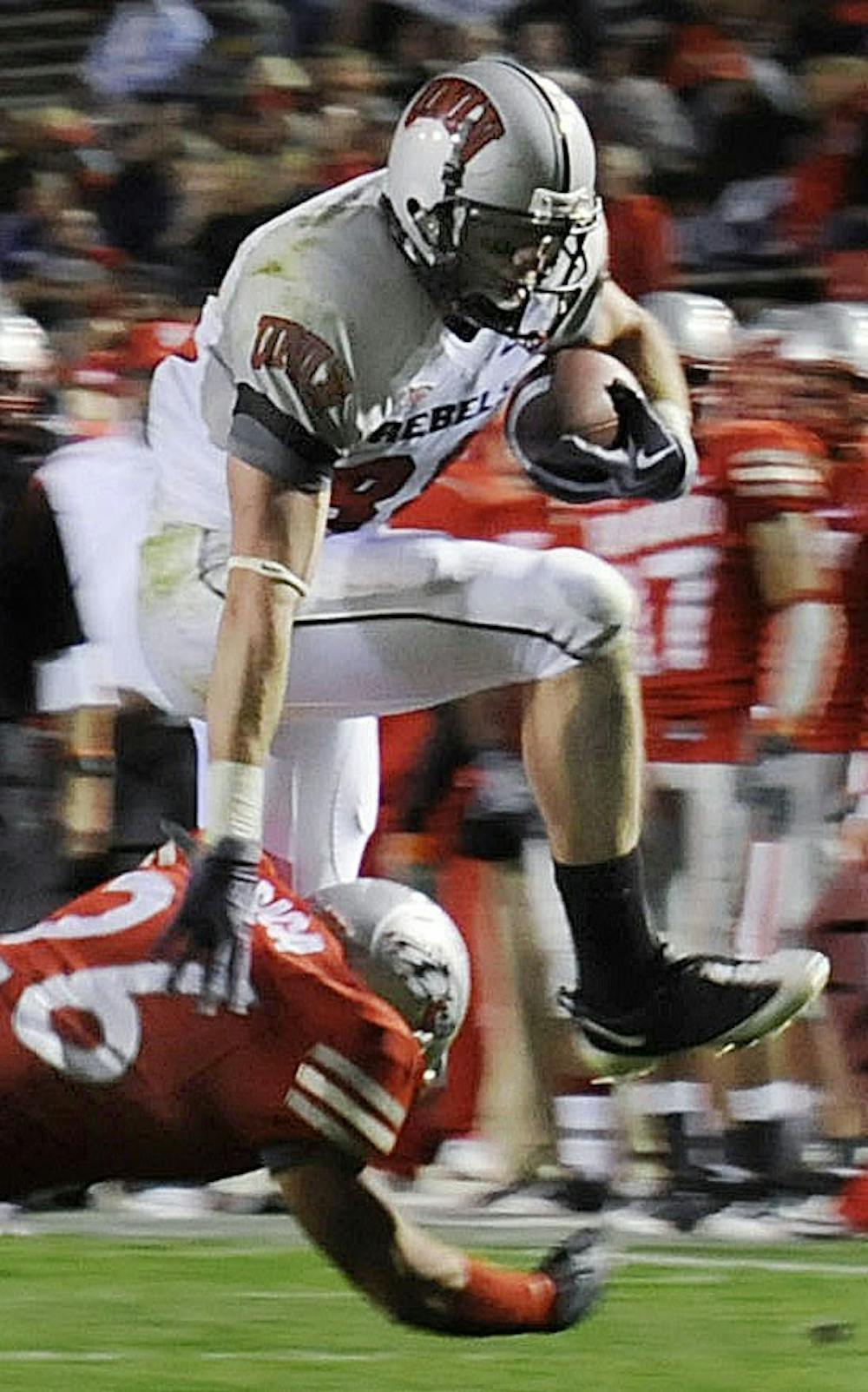 	UNLV wide receiver Ryan Wolfe hurdles over Lobo safety Frankie Baca in Saturday’s 34-17 drubbing at University Stadium. Wolfe had 11 receptions for 118 yards.