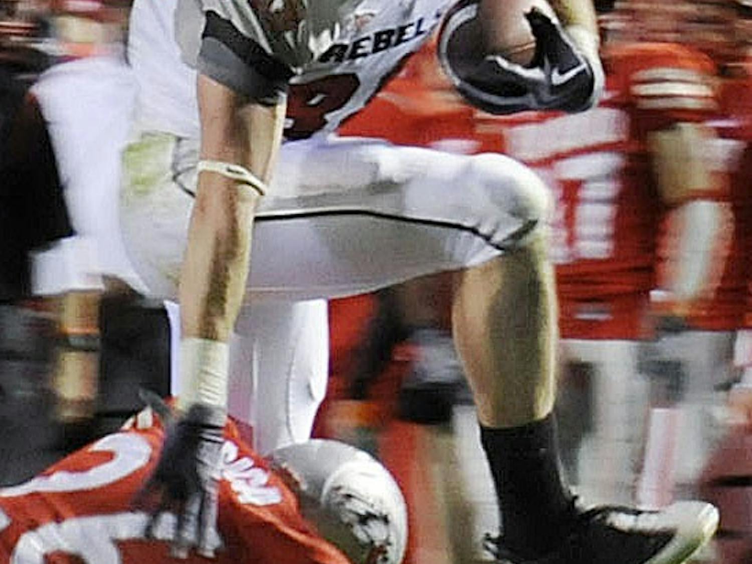 	UNLV wide receiver Ryan Wolfe hurdles over Lobo safety Frankie Baca in Saturday’s 34-17 drubbing at University Stadium. Wolfe had 11 receptions for 118 yards.