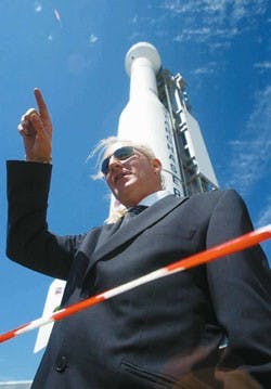 Fraser Roe gestures a rocket's trajectory while standing in front of the Nova/Starchaser 4 rocket at the Science and Technology Park on Friday. The rocket is part of a cross-country tour to educate about careers in privately owned space programs.