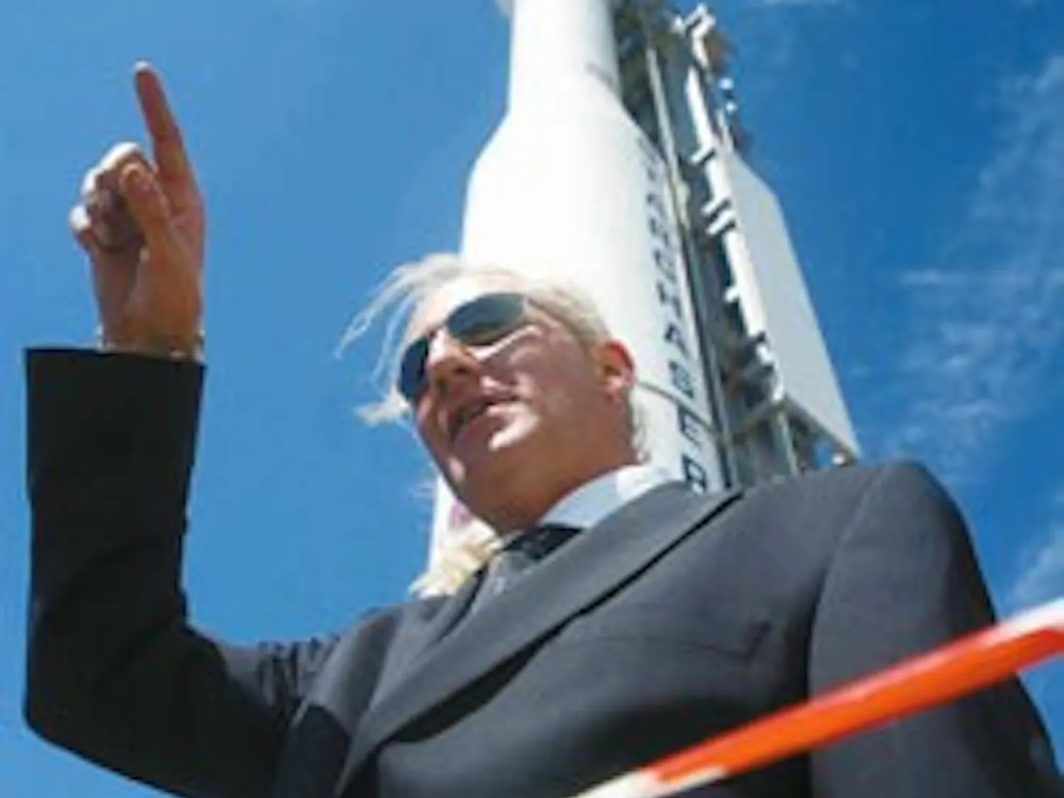 Fraser Roe gestures a rocket's trajectory while standing in front of the Nova/Starchaser 4 rocket at the Science and Technology Park on Friday. The rocket is part of a cross-country tour to educate about careers in privately owned space programs.