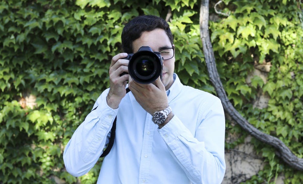 Caleb Cobos, owner of Caleb Cobos Photography poses for a photo at UNM where he recently graduated from with a degree in business.