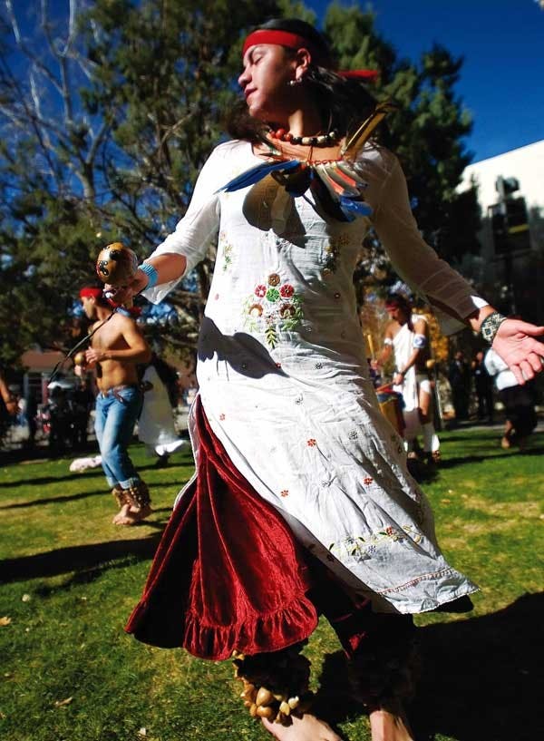 Student Jessica Herrera dances with members of Circulo Solar Ollin Xochipilli, a group that performs traditional Aztec dances. The group danced in front of El Centro de la Raza on Tuesday to celebrate the Mexican Revolution.  