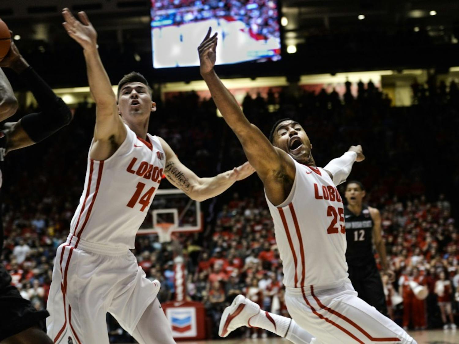 Freshman guard/forward Dane Kuiper (14) and senior guard Tim Jacobs (25) try to defend a San Diego State player Tuesday night at WisePies Arena. The Lobos will play Nevada this Saturday in Reno at 8 p.m.