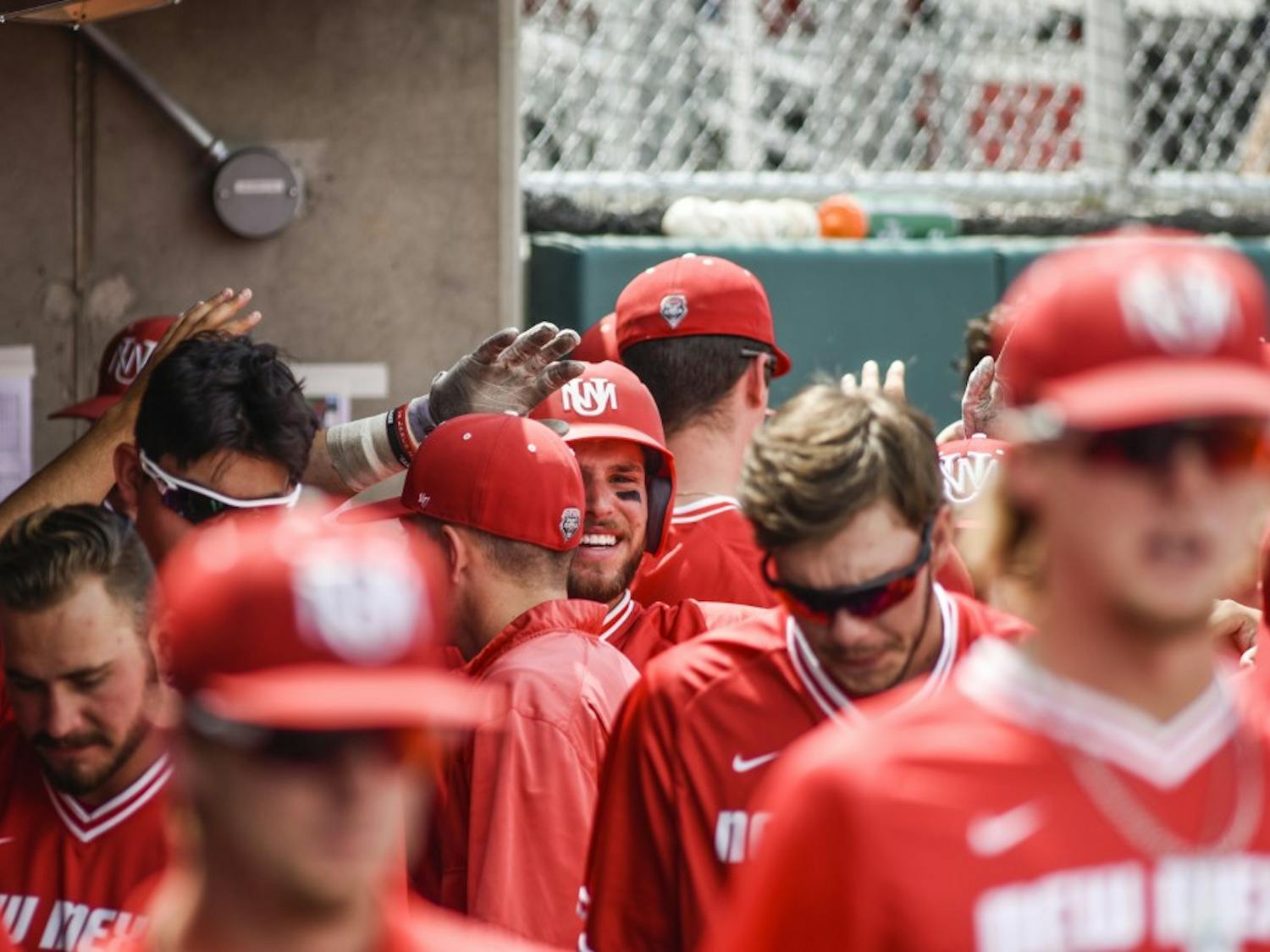 Junior Luis Gonzalez smiles and walks through the Lobo dug out after scoring a run against Air Force Saturday, May 6, 2017 at Santa Ana Star Field. The Lobos defeated Air Force&nbsp;11-6.