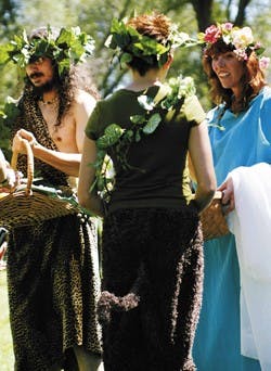 Amica Hunter, center, accepts bread from Connie Campbell, who is playing the role of Greek goddess Persephone, during a ceremony at Pagan Pride Day on Sunday at Baton Park. Campbell and Jugnu Ahluwalia, playing the role of Dionysus, left, "share the fruit