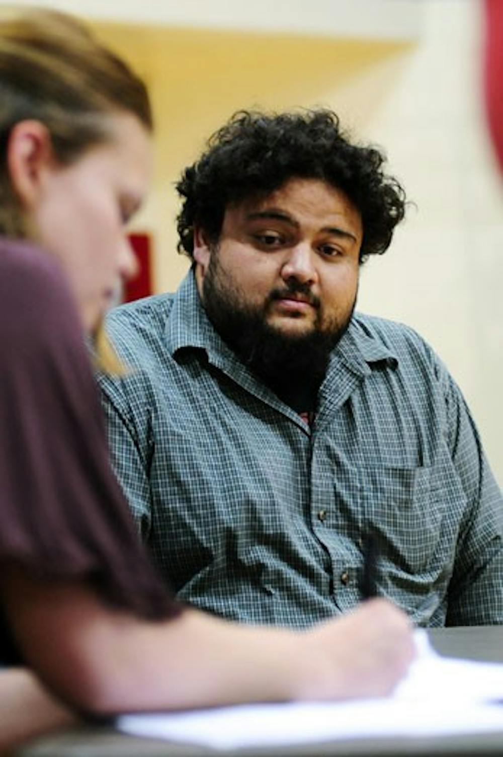 Sebastian Rael of the Albuquerque Kings watches as Katryn Fraher signs an agreement to allow the wheelchair basketball team to use Johnson Gym for free. 