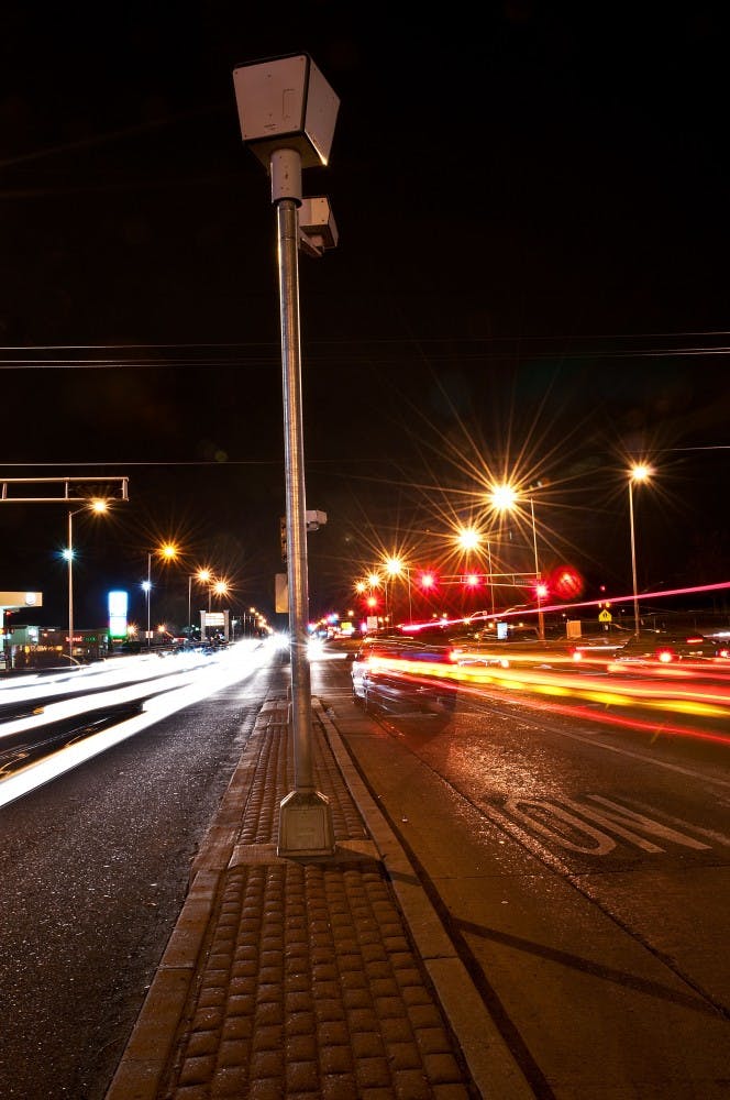 	Cars stream by the red light camera mounted at the intersection of San Mateo and Montgomery Boulevards on Tuesday evening. UNM is in the process of negotiating a study that would determine the viability of these cameras in Albuquerque intersections. 