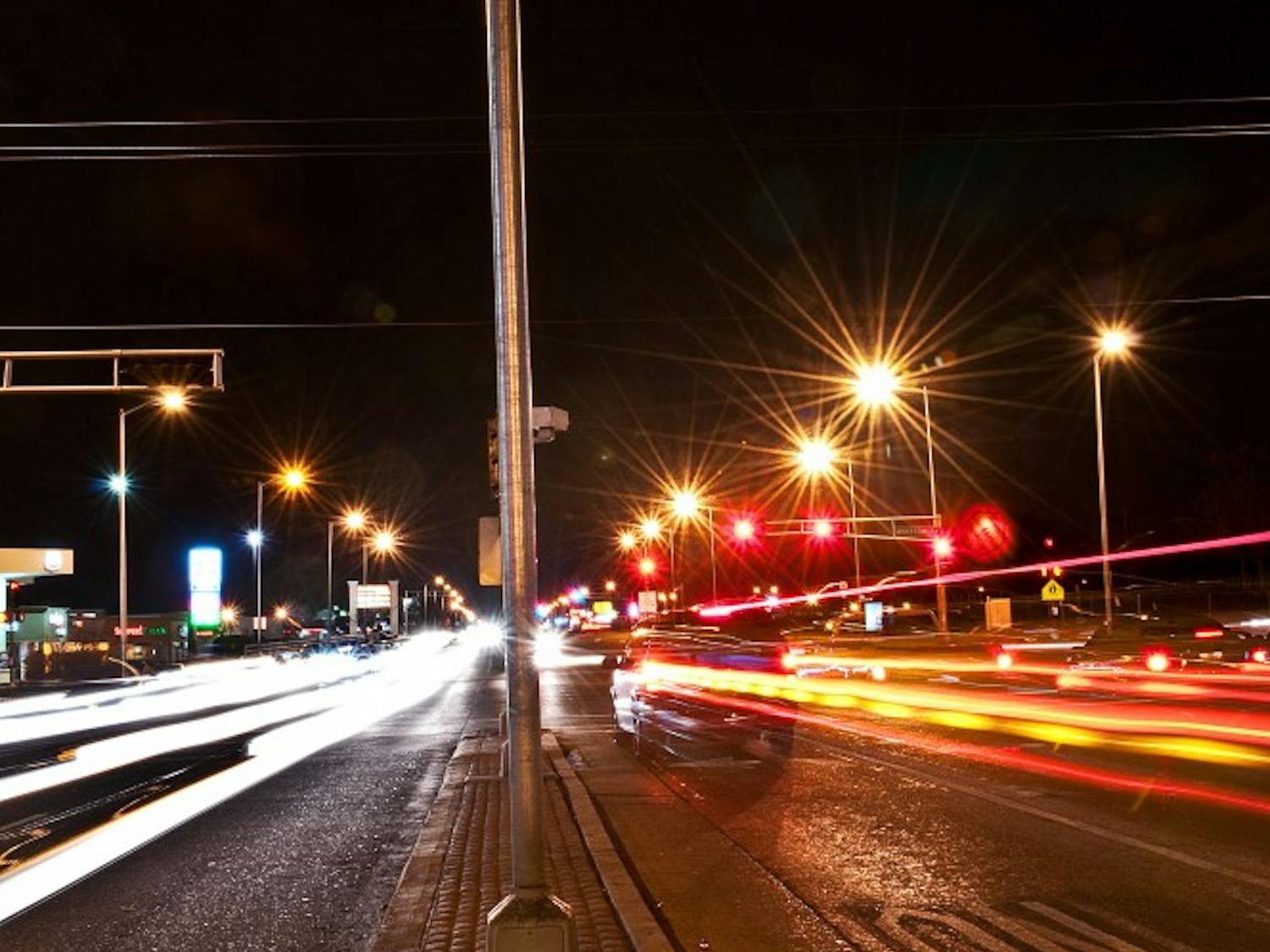 Cars stream by the red light camera mounted at the intersection of San Mateo and Montgomery Boulevards on Tuesday evening. UNM is in the process of negotiating a study that would determine the viability of these cameras in Albuquerque intersections.