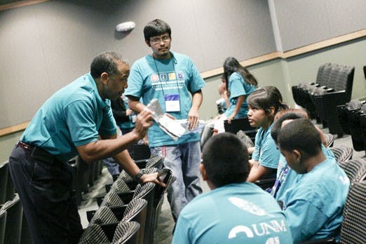 American astronaut Bernard Harris helps Summer Science Camp participants with a project while they work in the engineering building on Thursday. Harris, who was the first African-American astronaut in history, visited UNM for the camp.