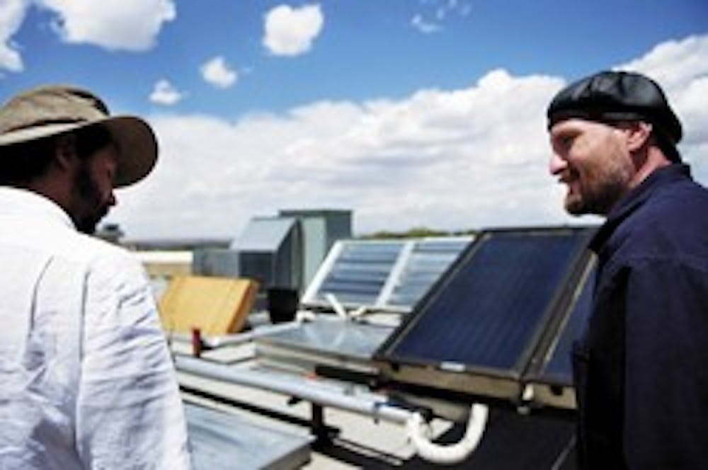 Assistant professors Andrea Mammoli, left, and Peter Vorobieff stand on the roof of the mechanical engineering building Tuesday. They received a $200,000 grant from the New Mexico Energy, Minerals and Natural Resources Department to renovate the solar pan