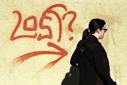 Student Kyla Worker walks by graffiti between Zimmerman Library and the SUB on Wednesday. 