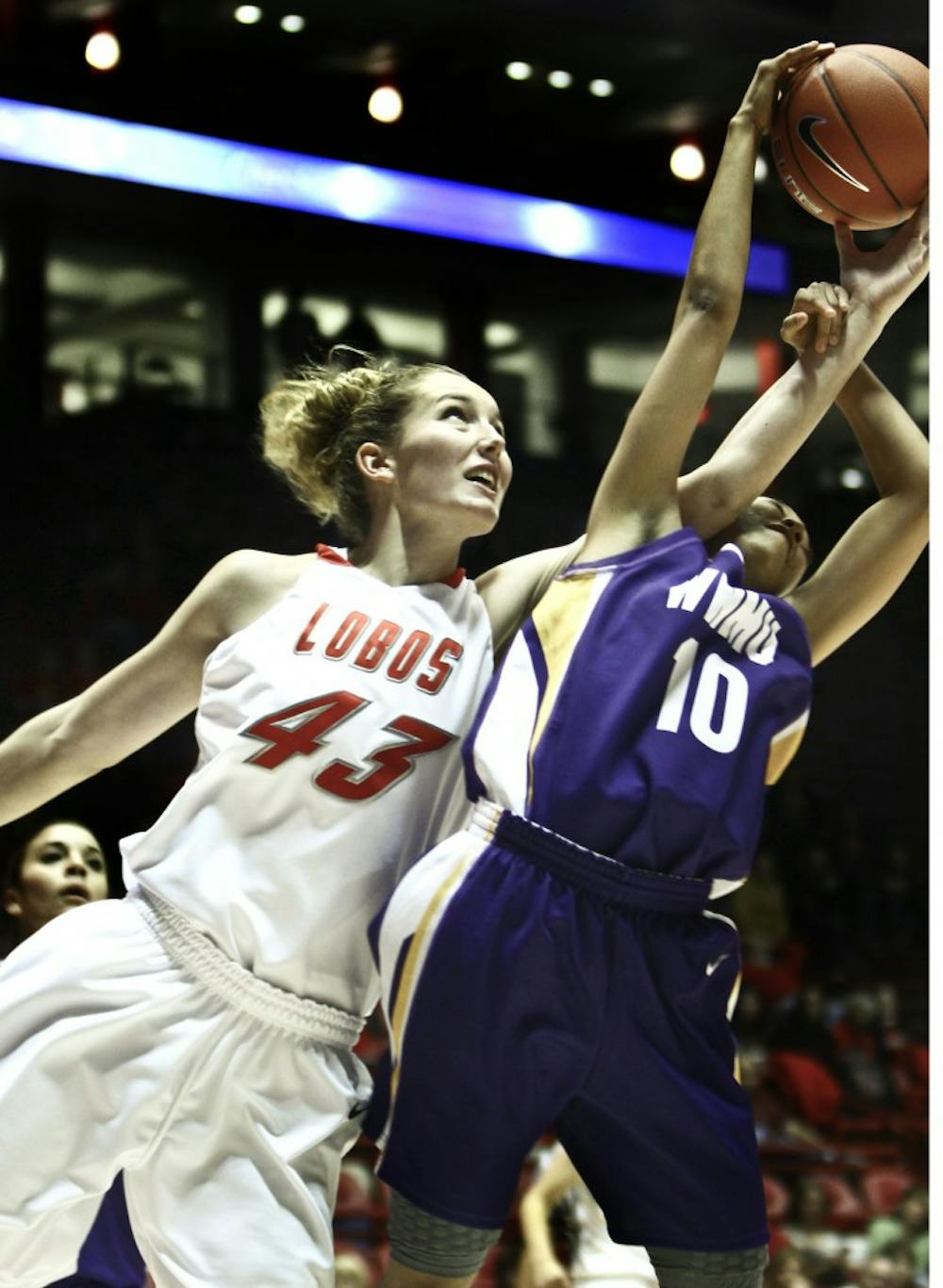 	UNM center Emily Stark rips the ball from Western New Mexico’s Shatwa Morris Tuesday at The Pit. The Lobos rolled to a 92-39 win in their
first and only exhibition game.