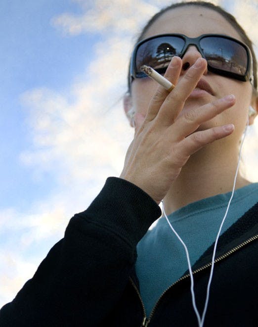 Alisha Catanach smokes between classes Tuesday. The Board of Regents says it needs more input from students before implementing a smoking ban on campus.
