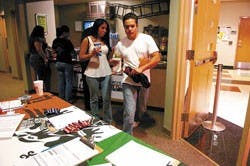 Katalina Gurule, left, and Alnair Lara walk past a voter registration table run by Movimiento Estudiantil Chicano de Aztlan of UNM on their way to view "The Men of Company E" at the Southwest Film Center on Monday.