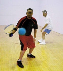 Tim Garcia, center, gets ready to hit a shot while playing racquetball against UNM employee Tom Root at Johnson Center on Friday. The two have been playing together for six years.
