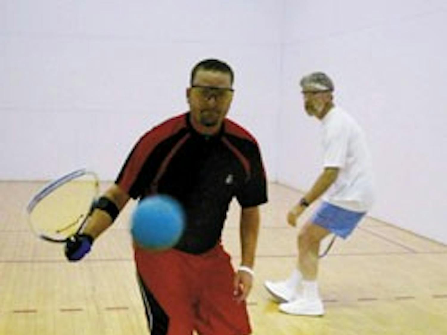 Tim Garcia, center, gets ready to hit a shot while playing racquetball against UNM employee Tom Root at Johnson Center on Friday. The two have been playing together for six years.