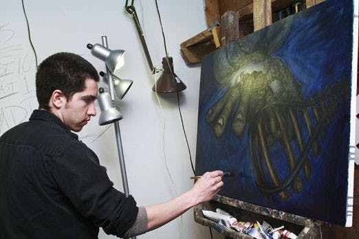 Reyes Padilla, painter and CNM student, paints at home in his studio on Monday. Padilla's work mainly focuses on the line between innocence and corruption. His work will be featured in a show at the Harwood Center from April 1-23 as part of a student  co-