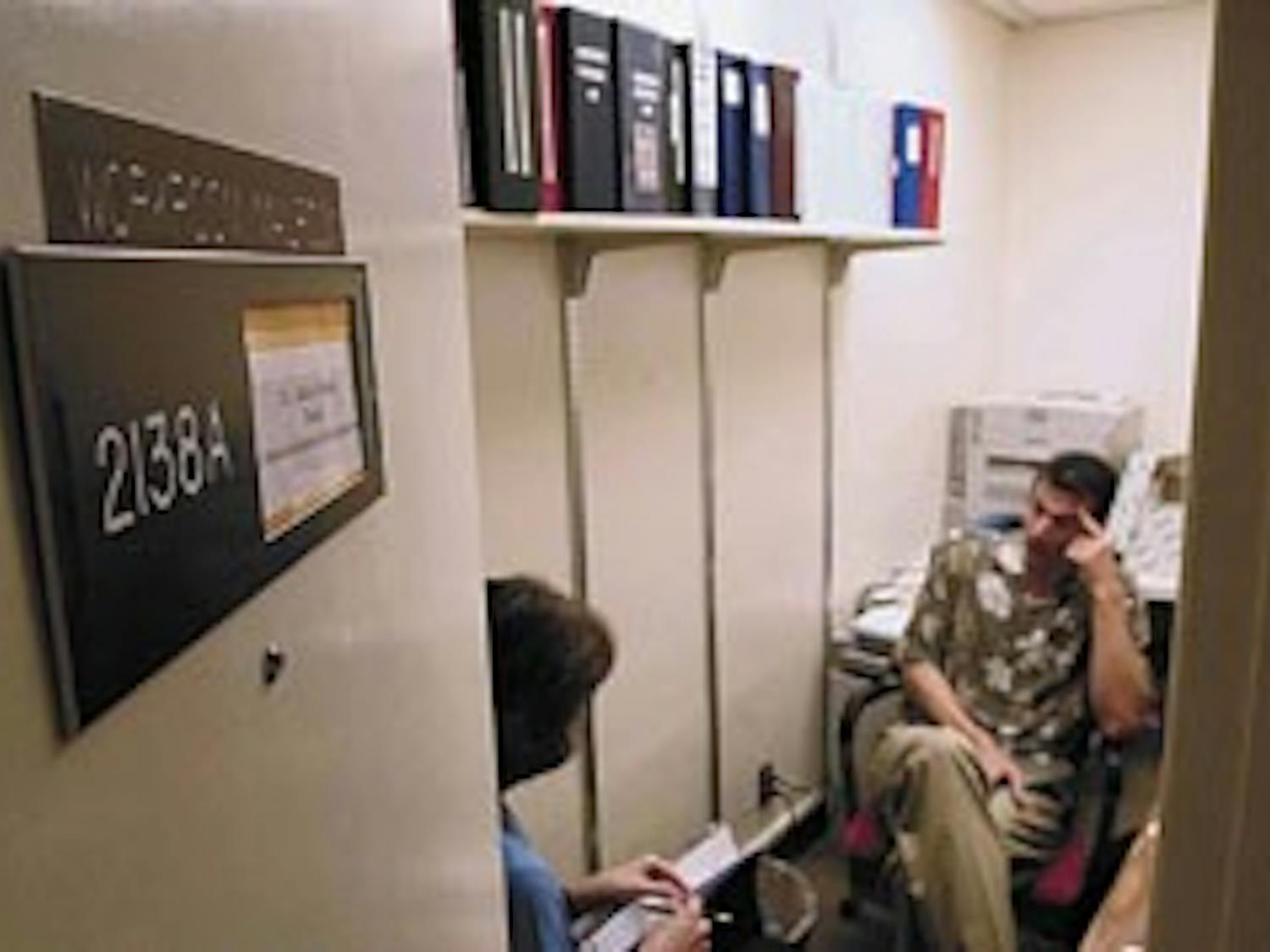 Ph.D. student Audrey Riffenburgh, left, talks with John Oetzel, communication and journalism chairman, during a meeting at his temporary office in Mesa Vista Hall on Wednesday.
