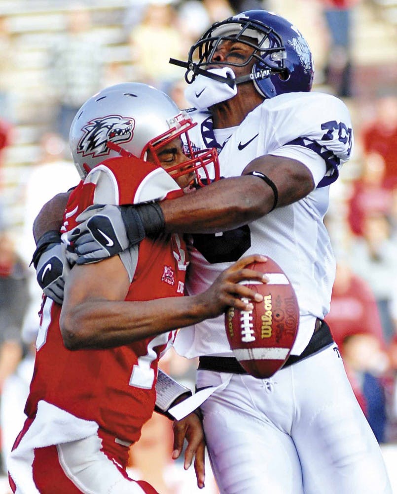 UNM quarterback Donovan Porterie, left, gets his helmet knocked off during a sack by TCU's Brian Bonner during the Lobos' 27-21 loss at University Stadium on Friday. Porterie started the game against TCU but was sidelined in the third quarter due to an in