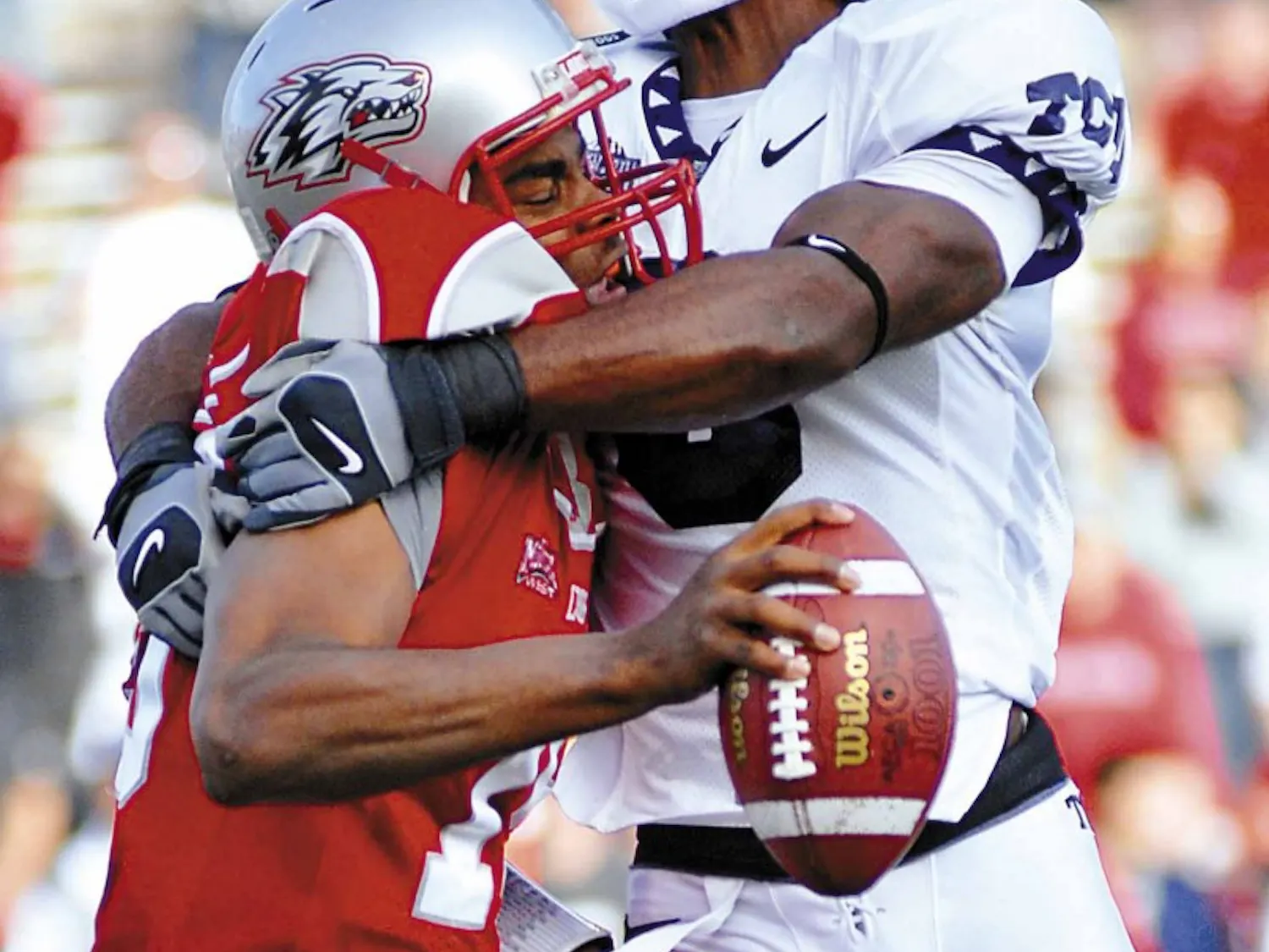 UNM quarterback Donovan Porterie, left, gets his helmet knocked off during a sack by TCU's Brian Bonner during the Lobos' 27-21 loss at University Stadium on Friday. Porterie started the game against TCU but was sidelined in the third quarter due to an in