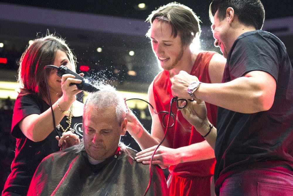 New Mexico men’s basketball head coach Craig Neal has his head shaved during Friday night’s Lobo Howl event at the Pit. Neal, along with his son, sophomore guard Cullen Neal, and senior guard Hugh Greenwood, has been growing out his hair to raise money for breast cancer awareness and show support for Greenwood’s mother, who was diagnosed with breast cancer more than 18 months ago.