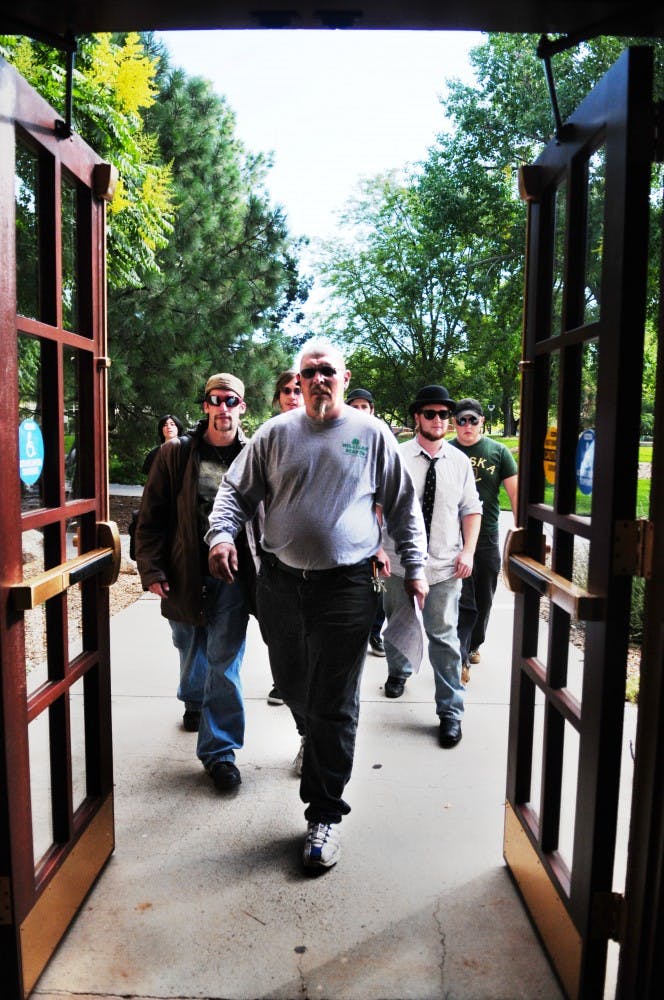 	Stephen Wills and a group of students walk into Scholes Hall on Thursday to hand in a petition requesting an exemption from the smoking ban for on-campus residence halls. The petition had 415 signatures.