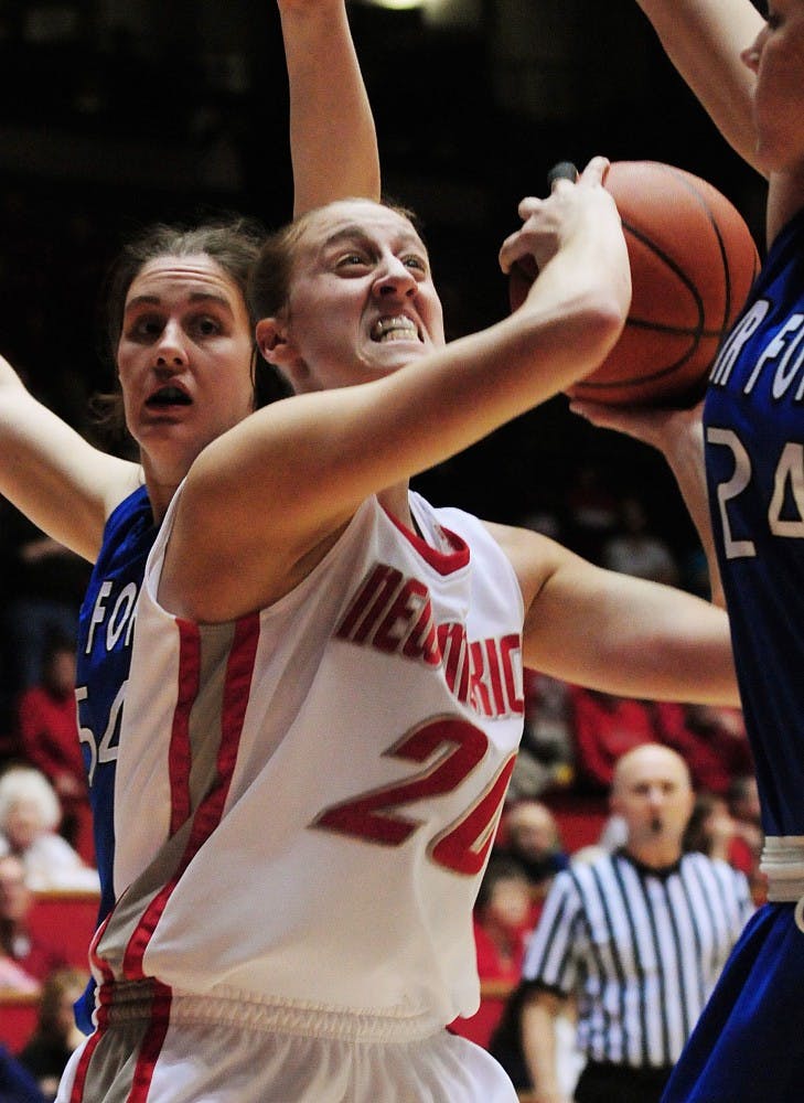 	Sara Halasz slashes past Air Force’s Katie Hilbig and puts up a contested shot in UNM’s 62-42 victory over the Falcons at The Pit on Wednesday. Halasz finished with 14 points and 11 rebounds.