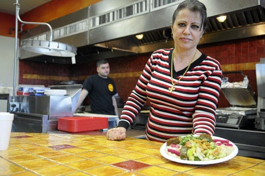 Helen Nesheiwat shows a dish prepared at Sahara Middle Eastern Eatery. Nesheiwat moved to the U.S. from Lebanon when she was 12. She co-owns Sahara and Times Square Deli Mart with her husband, Monir, and Haytham Khalil.