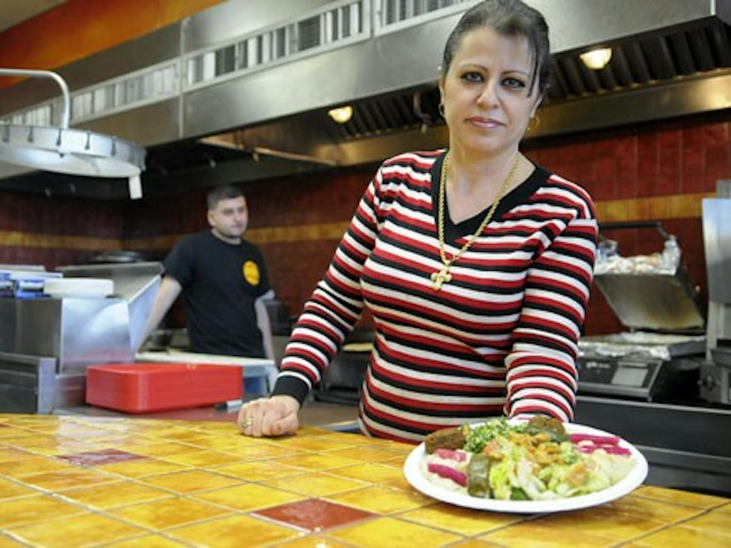 Helen Nesheiwat shows a dish prepared at Sahara Middle Eastern Eatery. Nesheiwat moved to the U.S. from Lebanon when she was 12. She co-owns Sahara and Times Square Deli Mart with her husband, Monir, and Haytham Khalil.