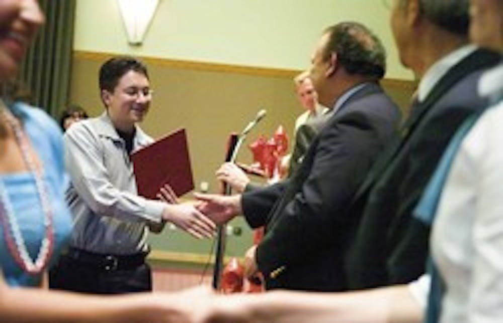 Highland High School junior David Roybal, center left, is congratulated by Eliseo "Cheo" Torres, vice president of Student Affairs, after receiving a certificate for being in the top 10 percent of his class. The certificates were handed out during the Sta