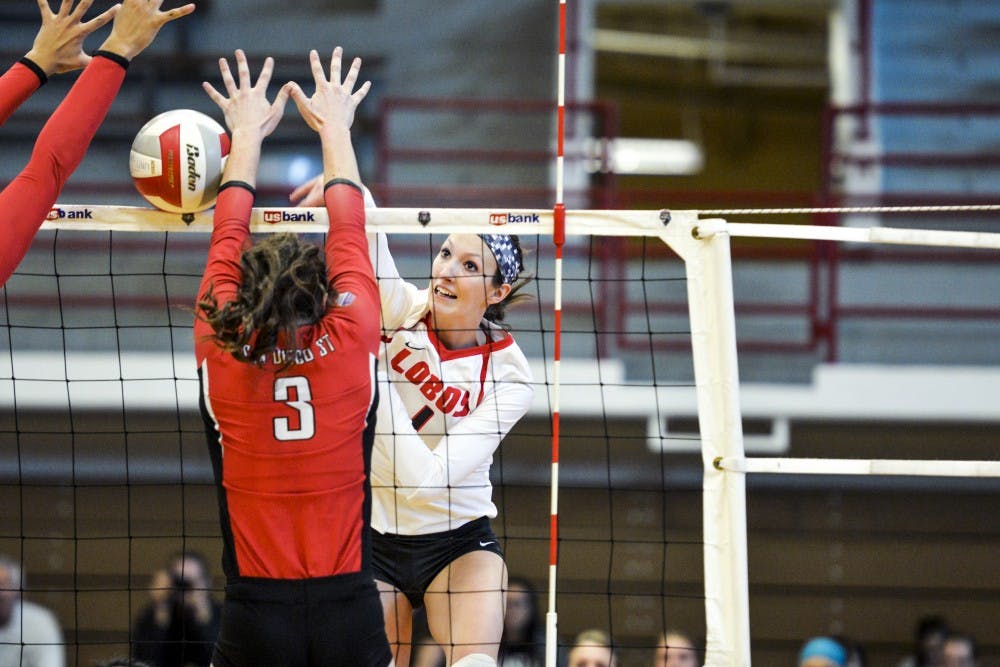 Senior outside hitter Devanne Sours sends the ball past two San Diego State University players Saturday, Nov. 19, 2016 at Johnson Center Gym. The Lobos beat the Aztecs in their last season game 3-0.&nbsp;