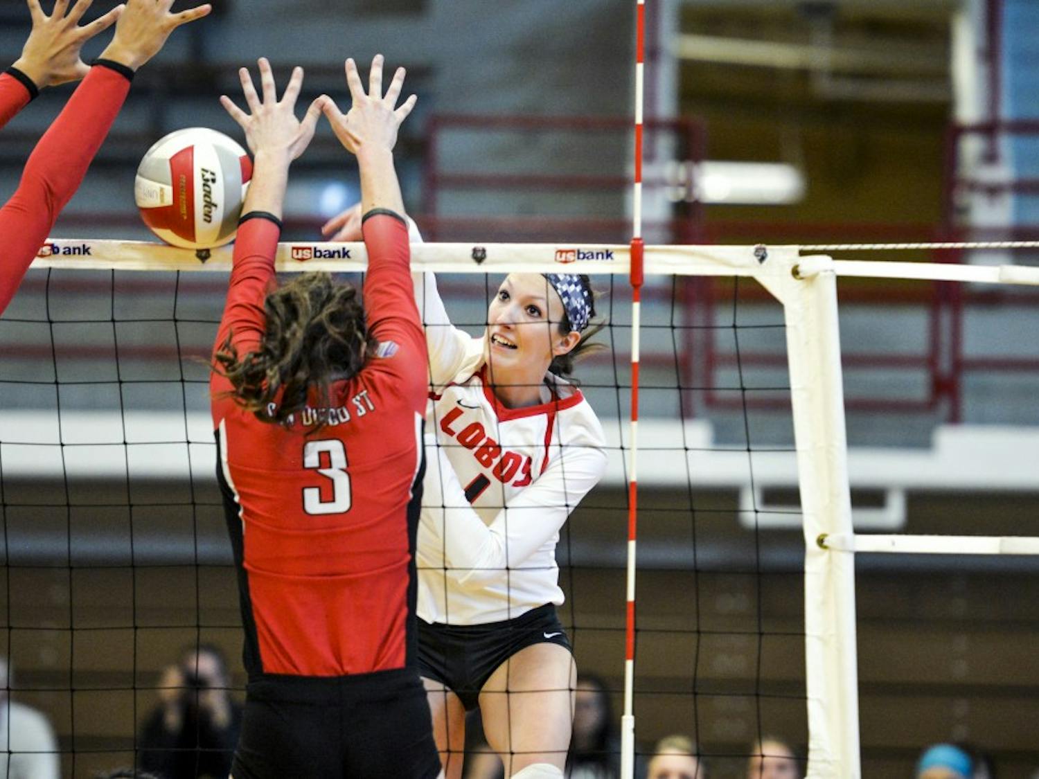 Senior outside hitter Devanne Sours sends the ball past two San Diego State University players Saturday, Nov. 19, 2016 at Johnson Center Gym. The Lobos beat the Aztecs in their last season game 3-0.&nbsp;