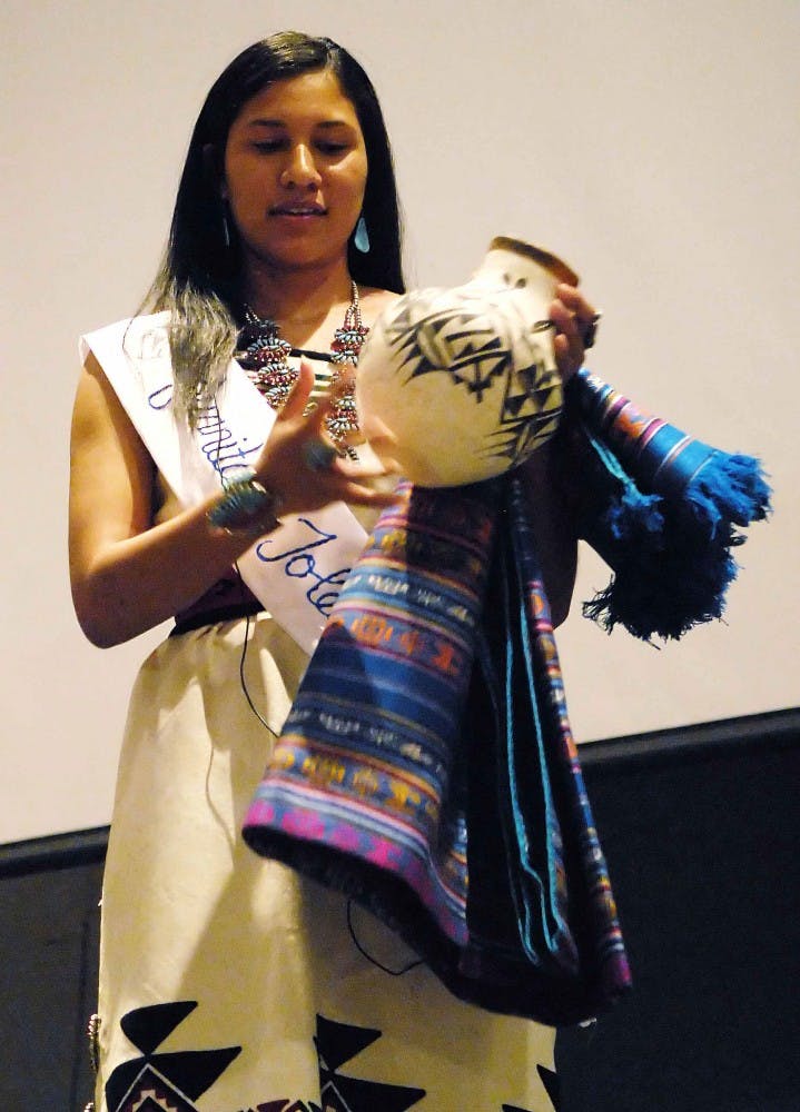 Juanita Toledo explains how stories are told with traditional paintings on clay pots during the Miss Indian UNM Pageant. Toledo was crowned Miss Indian UNM on Sunday in the SUB.